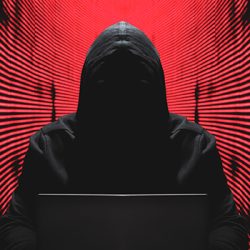 Ransomware report graphic: cyber criminal at a computer terminal